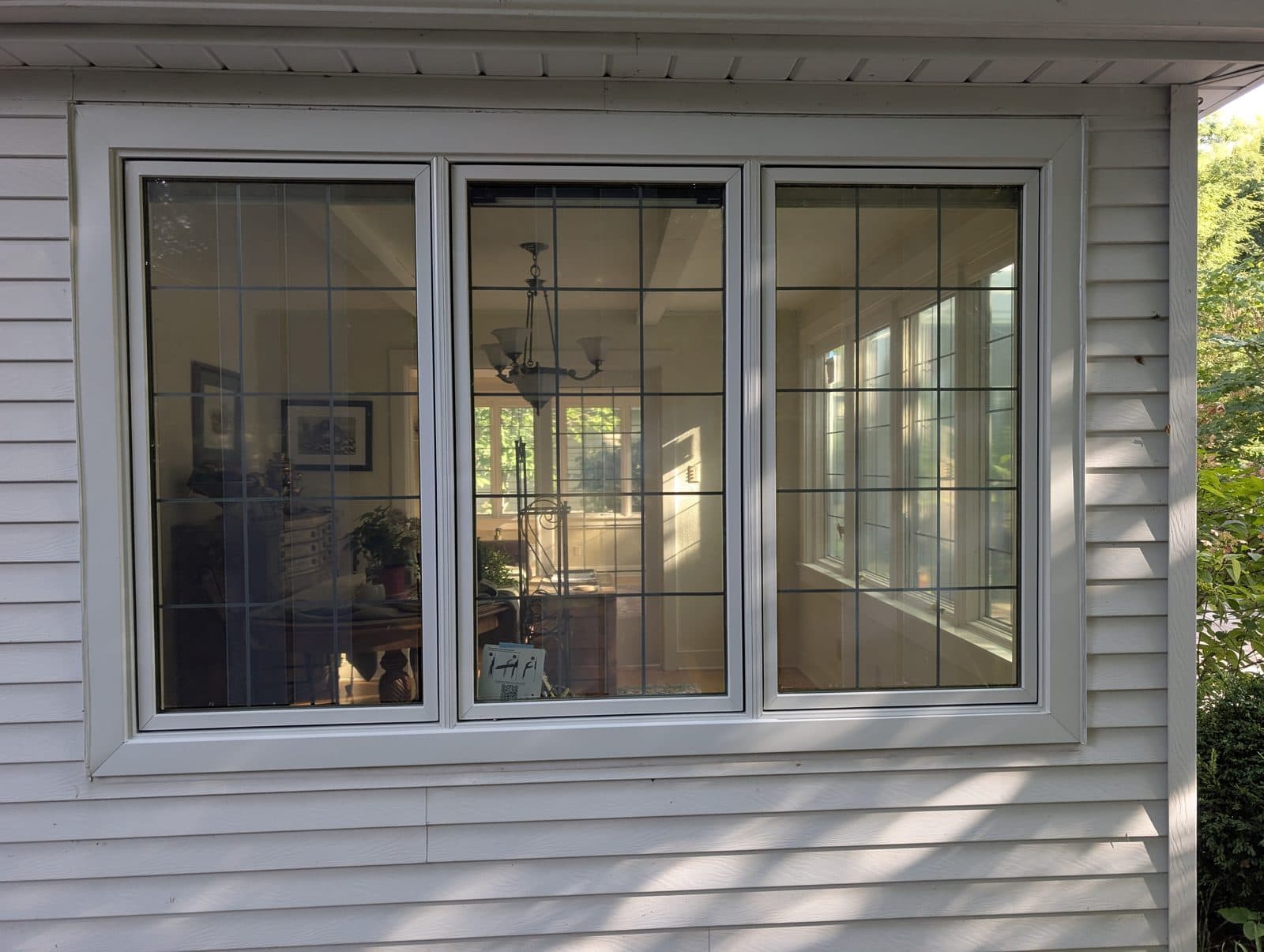 Three-lite casement window with leaded glass on a white-sided Southeast Wisconsin home