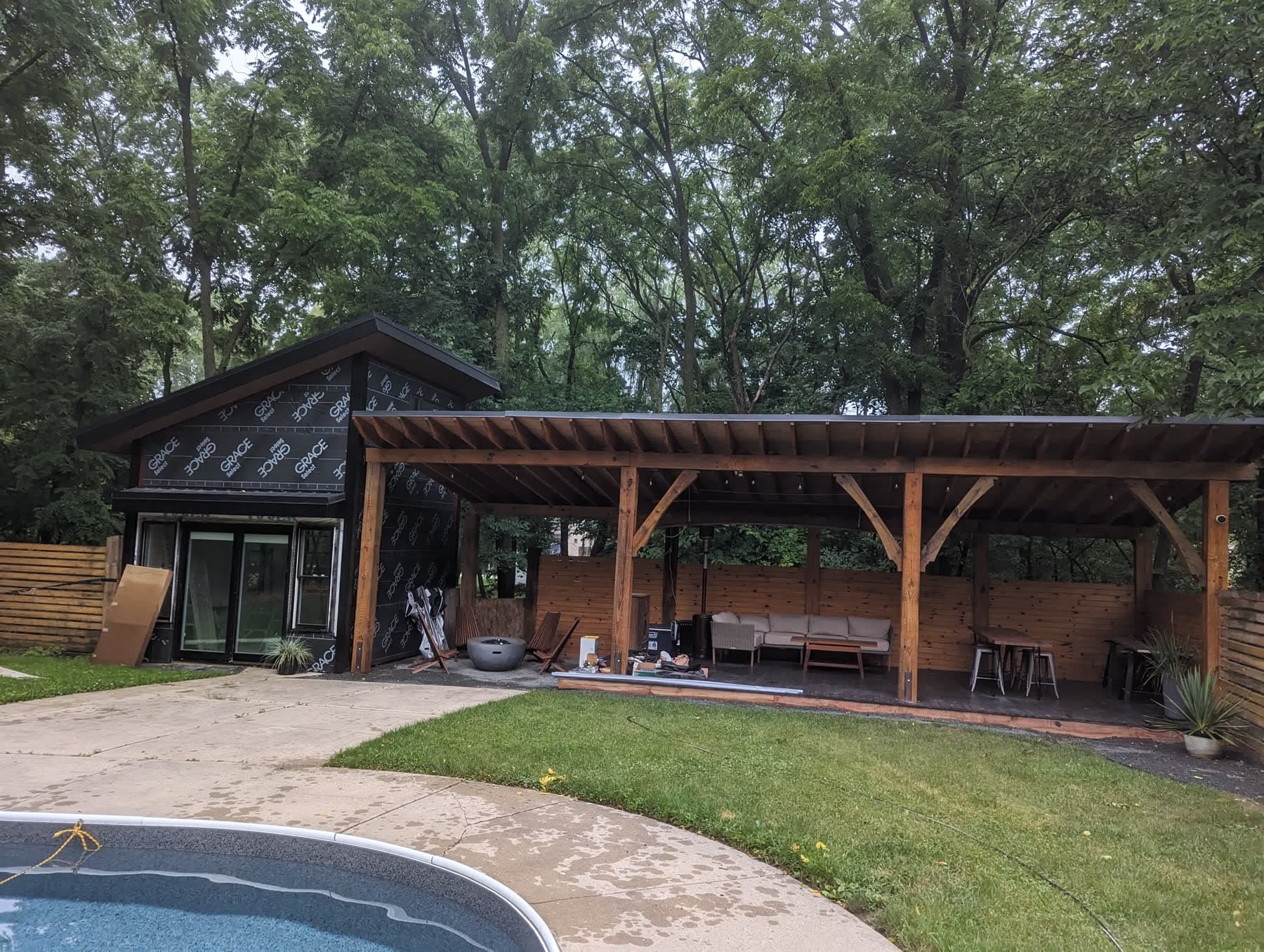 Custom composite deck with pergola beside a backyard pool, built in the Milwaukee area