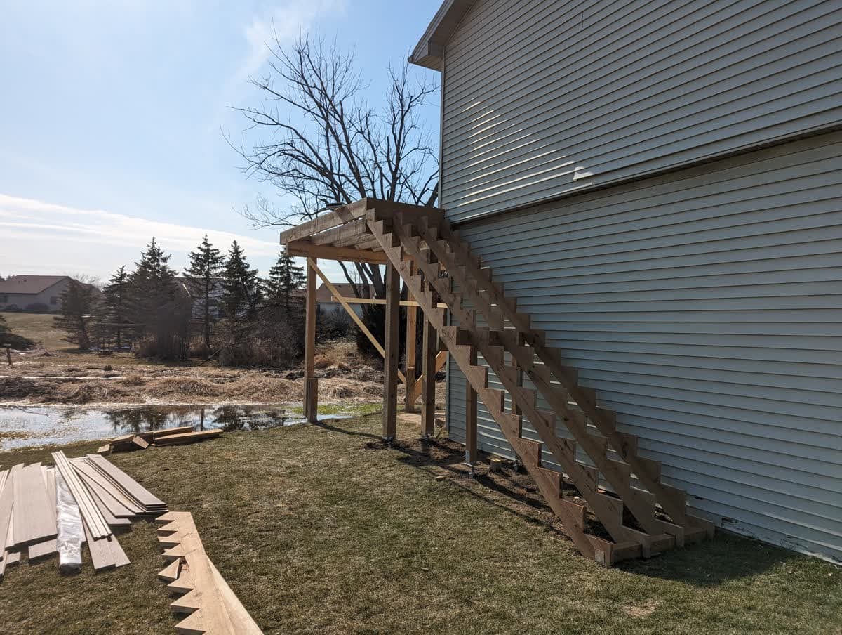 Tall elevated deck with a full-height staircase on a walkout home in Wisconsin