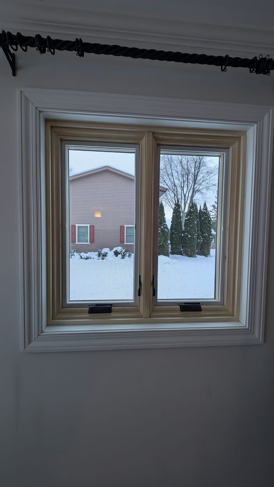 Wood-interior casement windows overlooking a snowy Wisconsin yard