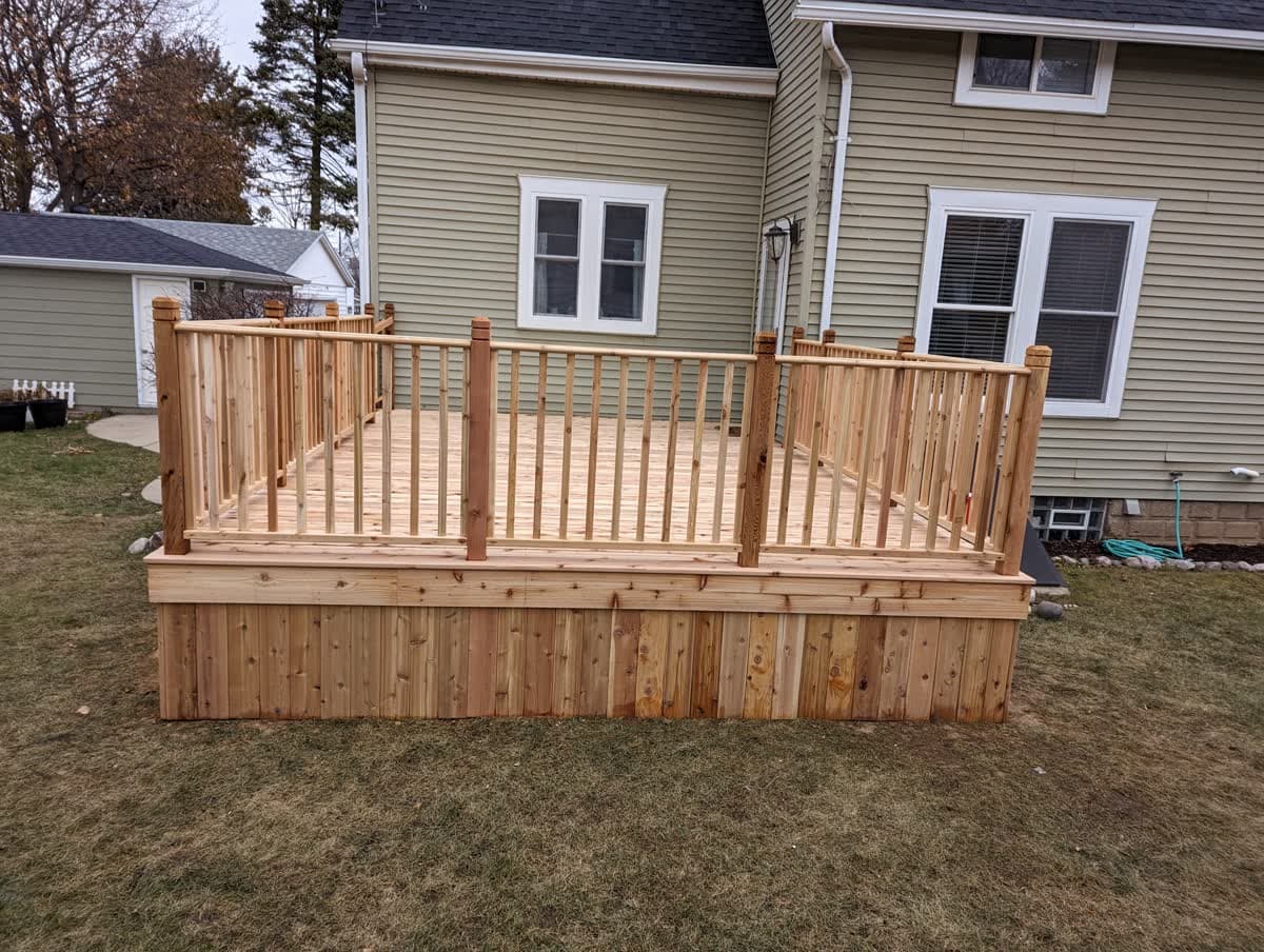 Backyard wood deck with railing and steps down to the yard in Wisconsin